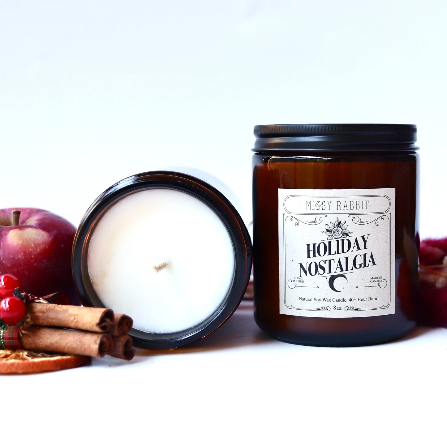 Two candles, one lit and one unlit, with a 'Holiday Nostalgia' label on a white background.