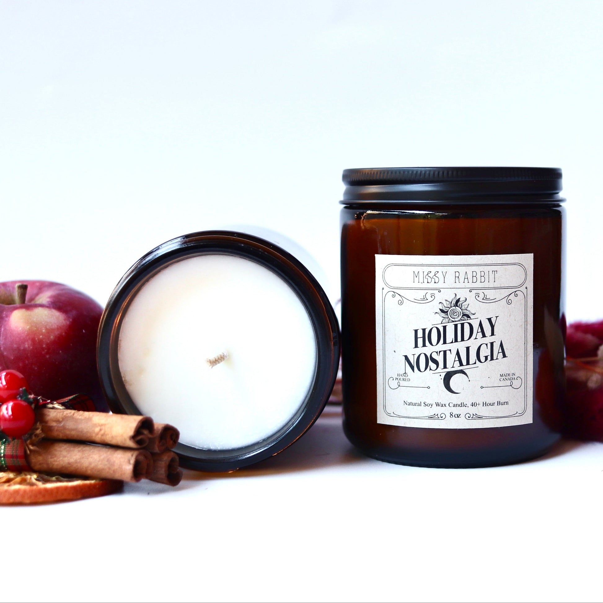 Two candles, one lit and one unlit, with a 'Holiday Nostalgia' label on a white background.